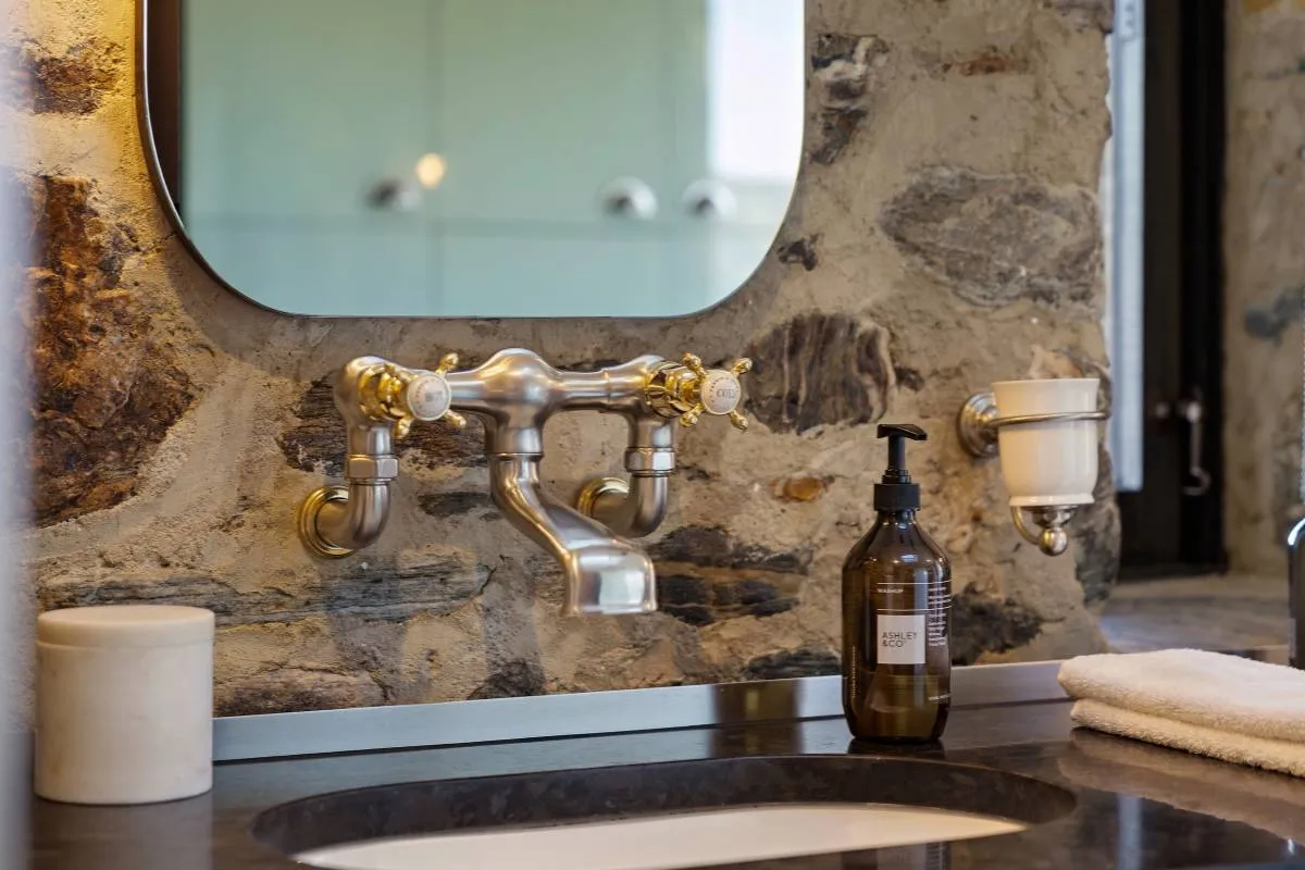 Brass tapware and a stone basin in a bathroom