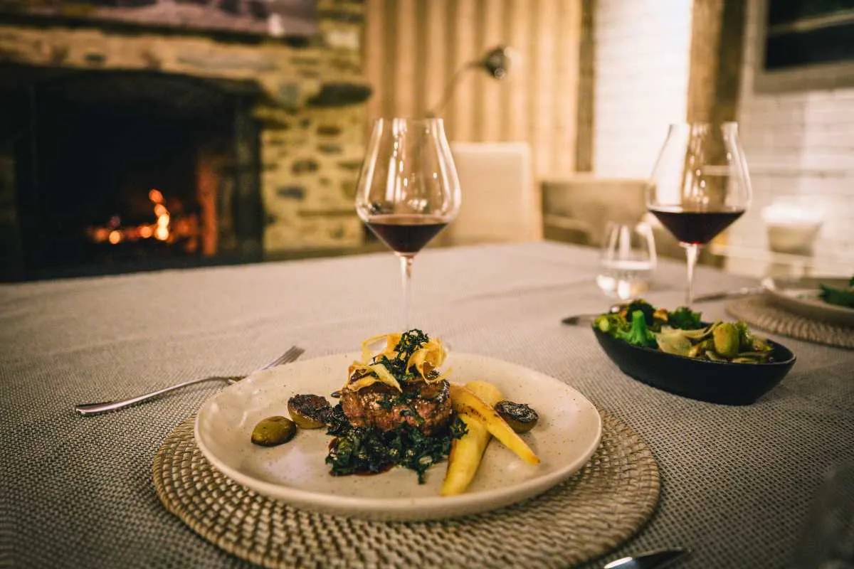 Cheese board and wine beside an open fire