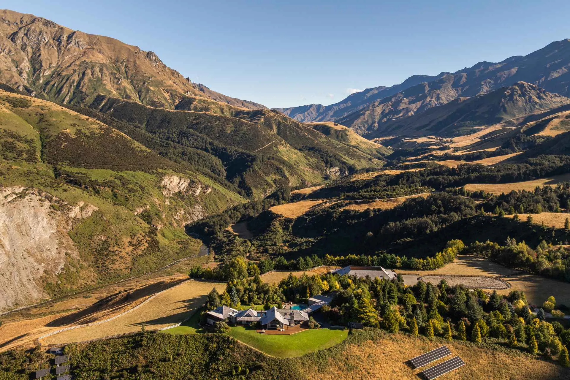 Mountain ranges and a lake beyond golden high-country hills